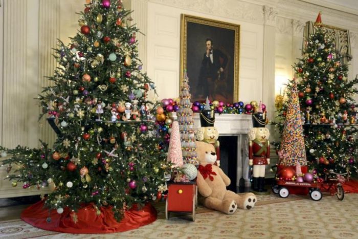 A portrait of the 16th U.S. President Abraham Lincoln flanks a pair of Christmas trees, toys, Nutcracker dolls and trimmings, in the State Dining Room of the White House, a preview of Holiday decorations being assembled for the season, in Washington, December 2, 2015.