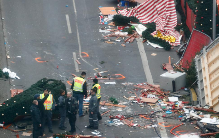 Policemen investigate the scene where a truck plowed into a crowded Christmas market in Berlin.