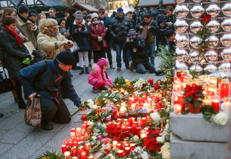 Mourners light candles at the Christmas market in Berlin, Germany, December 20, 2016, one day after a truck ploughed into a crowded Christmas market in the German capital.