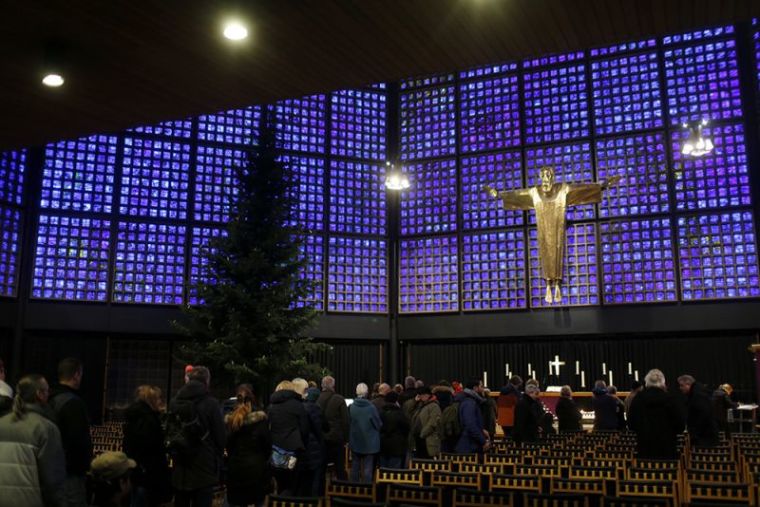 People gather at the Kaiser Wilhelm Gedaechtniskirche (Kaiser Wilhelm Memorial Church) in Berlin, Germany, December 21, 2016, after a truck ploughed through a crowd at the Christmas market on Monday night.