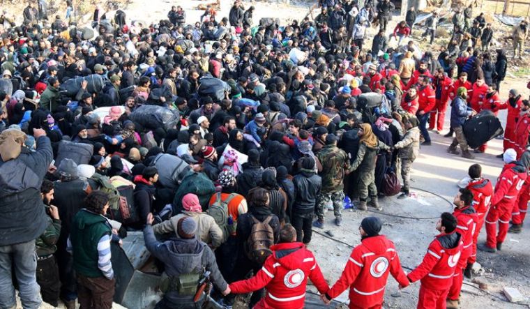 Red Crescent members hold hands while rebel fighters and civilians wait to be evacuated from a rebel-held sector of eastern Aleppo, Syria December 18, 2016.