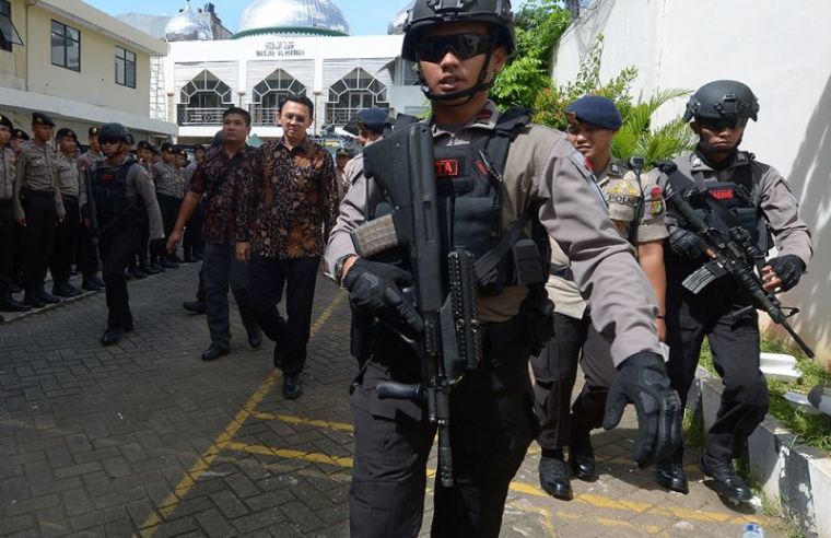 Jakarta's Christian governor Basuki Tjahaja Purnama alias Ahok (C) is escorted by anti-terror policemen as he leaves the North Jakarta court in Jakarta on December 20, 2016.