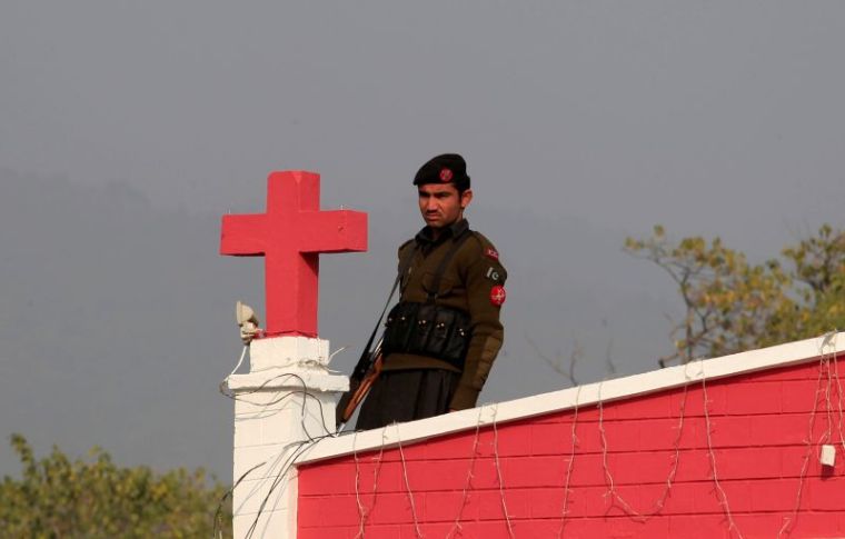 A Frontier Constabulary (FC) personnel stands guard at the rooftop of a church during a mass on Christmas in Islamabad, Pakistan, December 25, 2016.