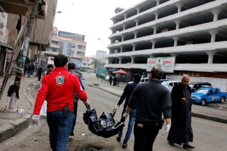 Medical personnel carry the body of a victim at the site of a bomb attack at a market in central Baghdad, Iraq, December 31, 2016.