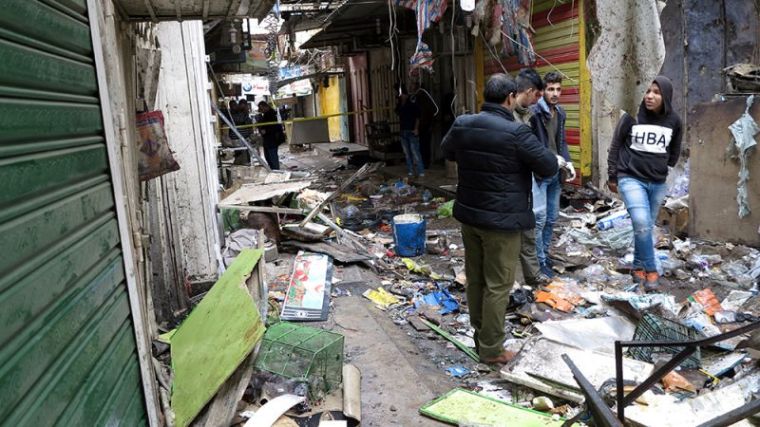 Iraqi security forces inspect the site of a bomb attack at a market in central Baghdad, Iraq, December 31, 2016.
