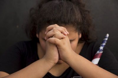 Middle School student Isabella Merle prays during a vigil for Marine Lance Cpl. Squire K.