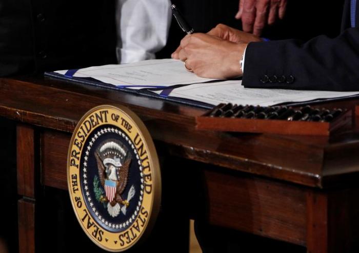 U.S. President Barack Obama signs the Affordable Care Act, dubbed Obamacare, the comprehensive healthcare reform legislation during a ceremony in the East Room of the White House in Washington, U.S., March 23, 2010.