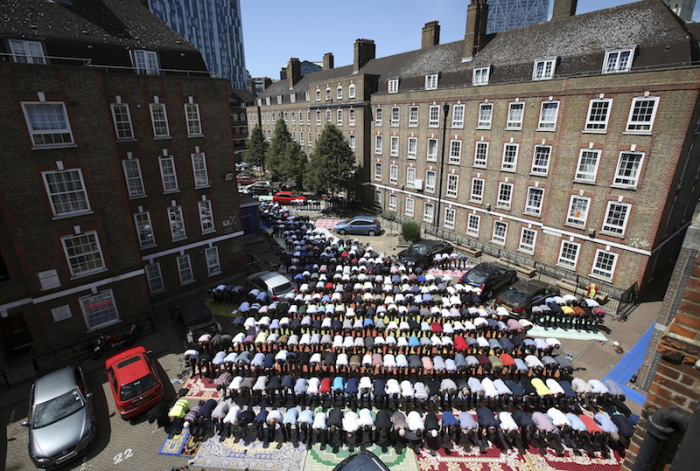 Muslims attend Friday prayers in the courtyard of a housing estate next to the small BBC community center and mosque in east London, England, July 10, 2015.