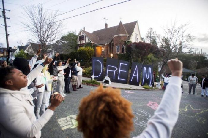 Black rights protesters gather near illuminated letters spelling 'DREAM' outside a house which they identified as the residence of Oakland Mayor Libby Schaaf, in Oakland, California January 19, 2015.