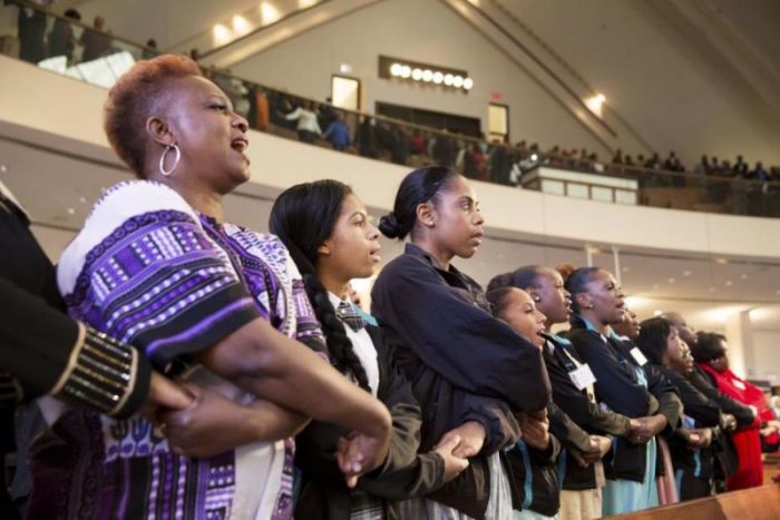 People sing 'We Shall Overcome' at the conclusion of The King Center's 47th Annual Martin Luther King Jr. Commemorative Service in Atlanta January 19, 2015.