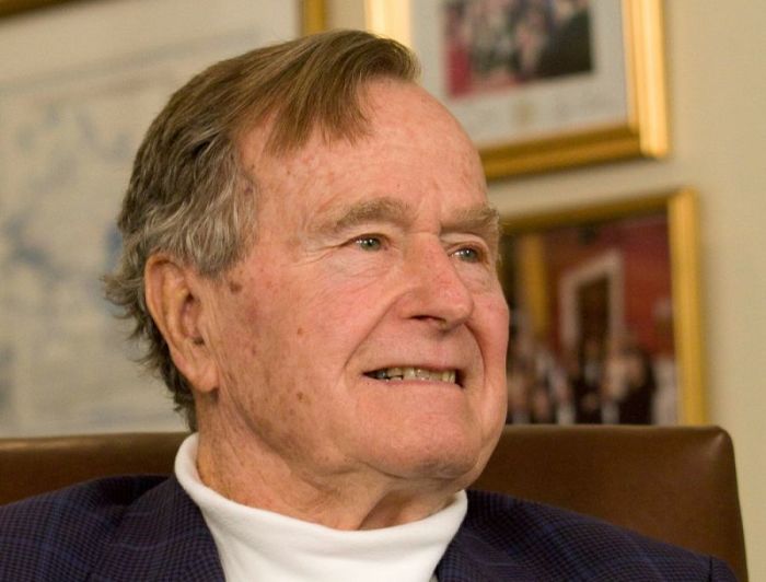 Former President George H.W. Bush smiles as he listens to Republican presidential candidate Mitt Romney speak as he met with Bush to pick up his formal endorsement in Houston in this March 29, 2012 file photo.