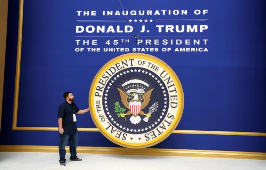 Workers install the presidential seal at the site of the Commander in Chief inaugural ball for President-elect Donald Trump in Washington, D.C. January 19, 2016.