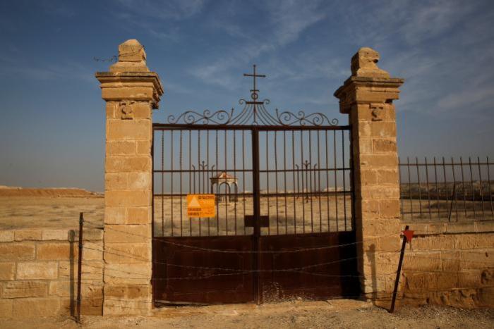 A gate, part of an abandoned church property, with a sign warning against land mines, is seen near Qasr Al-Yahud, Jesus' traditional baptismal site along the Jordan River, near Jericho in the West Bank, January 18, 2017.