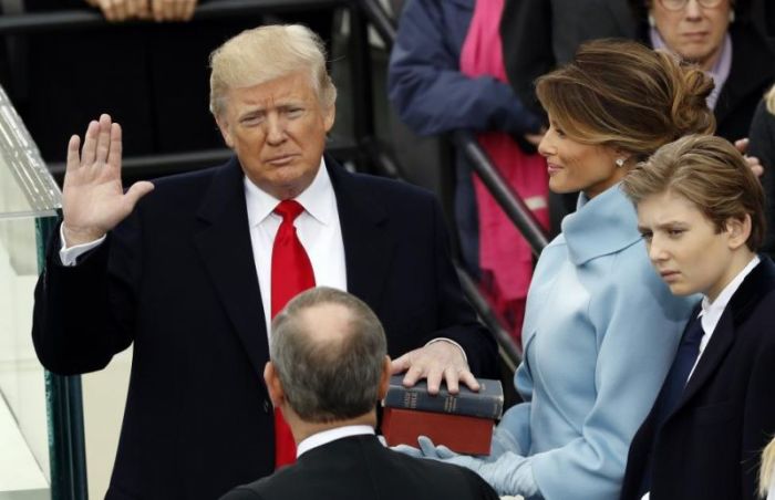 Donald Trump takes the oath of office with his wife Melania and son Barron at his side.