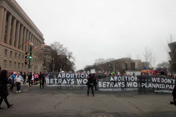 Demonstrators with Students for Life of American jump to the front of the Women's March on Washington with three large banners that speak out against abortion and Planned Parenthood on January 21, 2017.