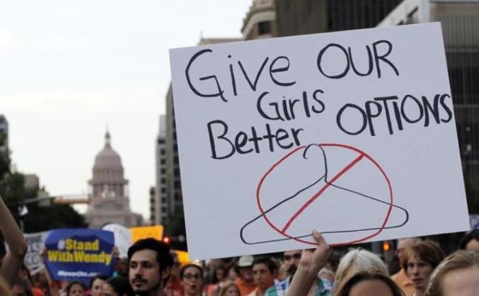 File photo of protesters carrying signs during an abortion rights march that originated at the State Capitol in Austin, Texas, July 8, 2013.