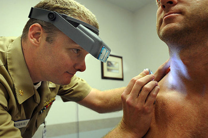 File: Examination of a Sailor using a dermatascope and magnifying loops during a skin cancer screening at Naval Special Warfare medical clinic at Naval Amphibious Base, Coronado.