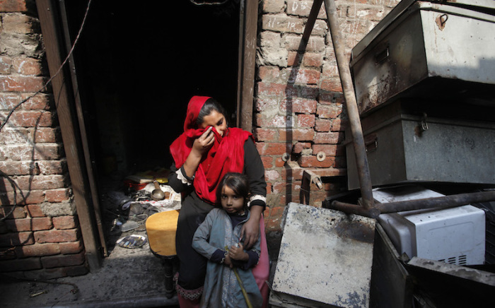 Anzila Semeul cries while sitting with her daughter in front of their home, after it was burnt by a mob two days earlier, in Badami Bagh, Lahore March 11, 2013. Hundreds of Pakistani Christians took to the streets across the country on Sunday, demanding better protection after a Christian neighbourhood was torched in the city of Lahore a day earlier in connection with the country's controversial anti-blasphemy law.