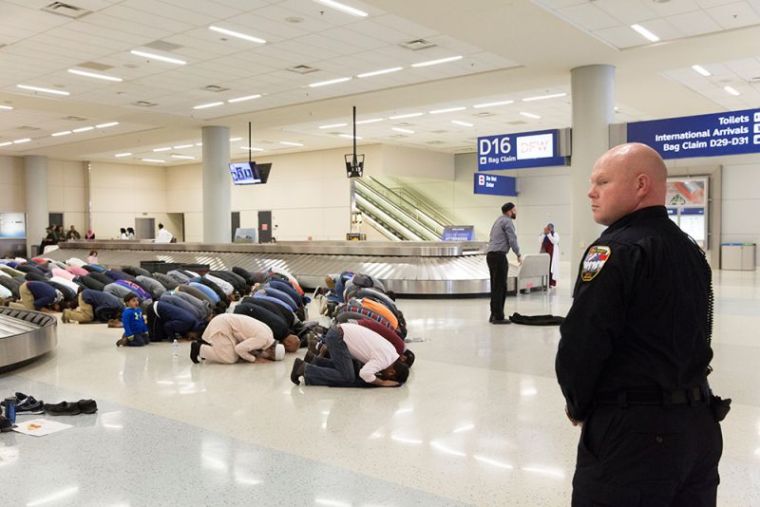 People gather to pray in baggage claim during a protest against the travel ban imposed by U.S. President Donald Trump's executive order, at Dallas-Fort Worth International Airport in Dallas, Texas, January 29, 2017.