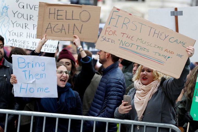 Activists gather outside the Trump International Hotel to protest President Donald Trump's executive actions on immigration in Washington, January 29, 2017.