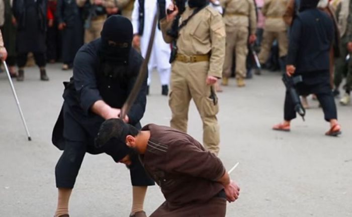 An Islamic State executioner beheads a victim in this undated screengrab.