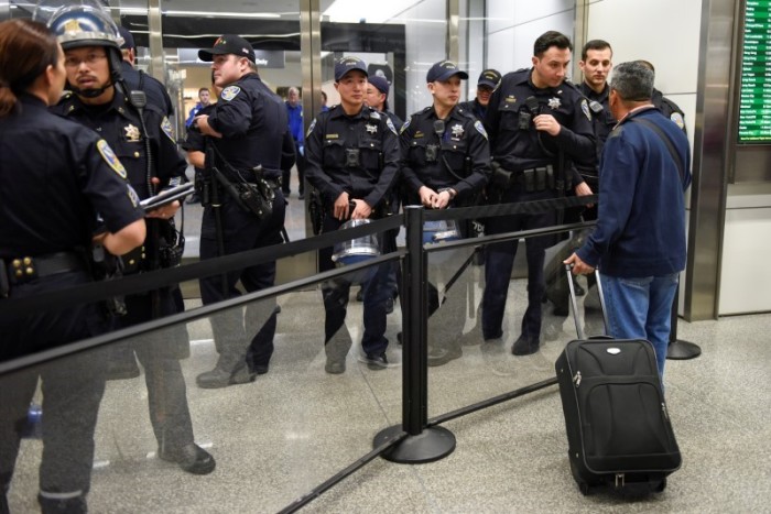 Police redirect travelers after the security check point was closed due to protests in Terminal 4 at San Francisco International Airport in San Francisco, California, U.S., January 28, 2017.