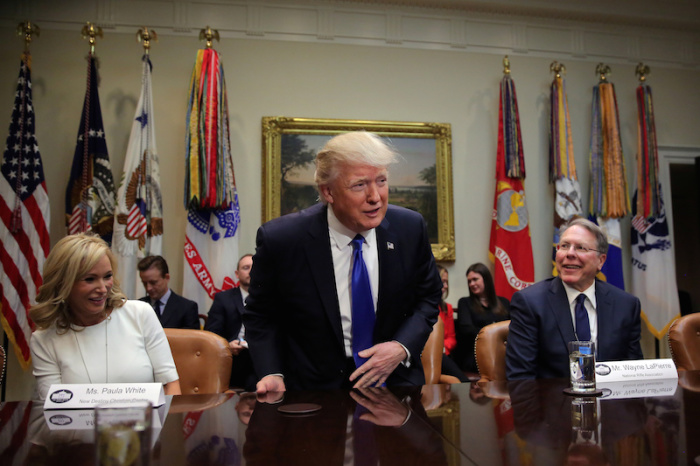 U.S. President Donald Trump attends a meeting regarding the supreme court nomination, accompanied by Wayne LaPierre (R), executive vice president of the National Rifle Association and Paula White (L) from the New Christian Destiny Center at the Roosevelt room of the White House in Washington U.S., February 1, 2017.