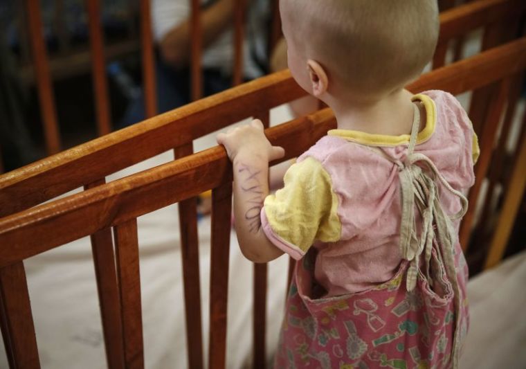 A child, whose name is written on arm, stands in a crib in an orphanage in Kramatorsk August 30, 2014. 76 children from orphanages in Donetsk and Makeyevka in eastern Ukraine were sent to Kramatorsk due to fighting between the Ukrainian army and pro-Russian separatists.