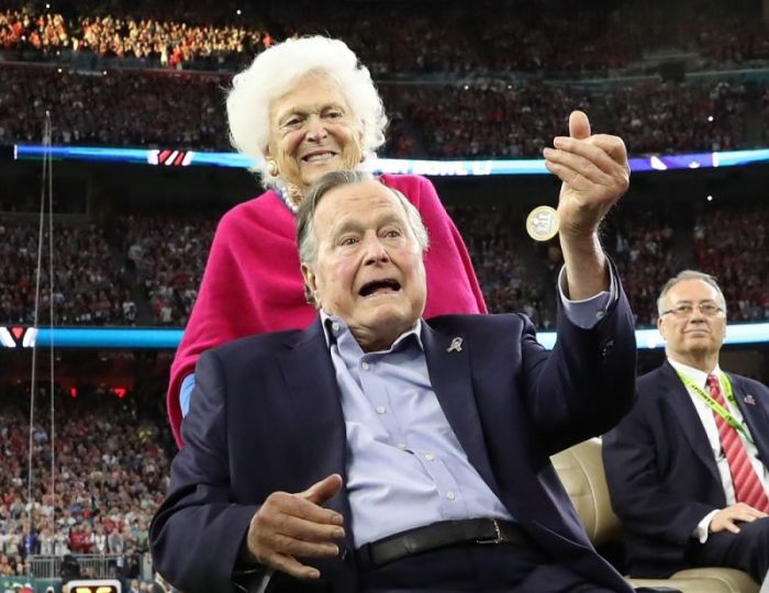 Former U.S. President George H.W. Bush participates in the coin toss ahead of the start of Super Bowl LI between the New England Patriots and the Atlanta Falcons as former first lady Barbara Bush looks on in Houston, Texas on Feb. 5, 2017.