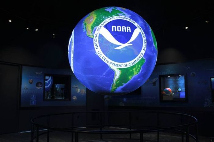 A glowing 6-foot diameter sphere, suspended from the ceiling of NOAA headquarters in Silver Spring, Maryland, is the 100th NOAA Science On a Sphere installed around the world.