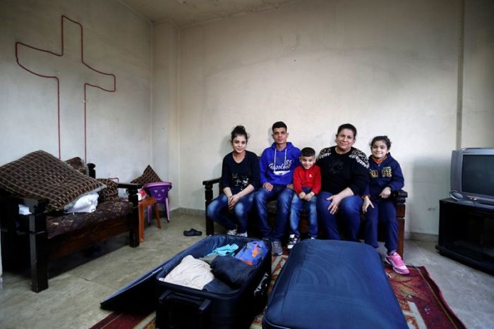 The al-Qassab family, Iraqi Christian refugees from Mosul, pose near their luggage ahead of their travel to the United States at their temporary home in Beirut, Lebanon, February 7, 2017.
