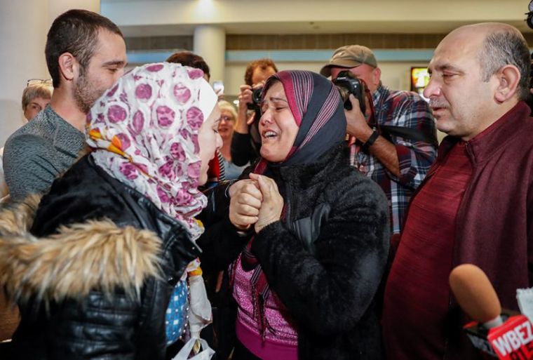 Syrian refugee Baraa Haj Khalaf (L) reacts as her mother Fattoum (C) cries and her father Khaled (R) looks on after arriving at O'Hare International Airport in Chicago, Illinois, February 7, 2017.