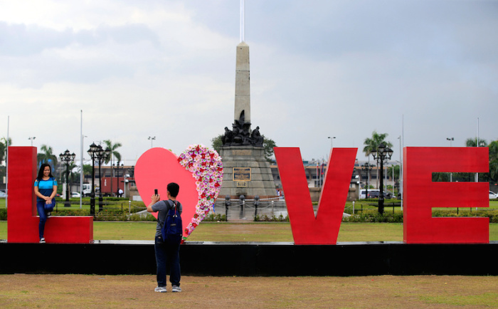 People take pictures of a 'LOVE' display day before Valentine's Day in Rizal park, metro Manila, Philippines February 13, 2017.