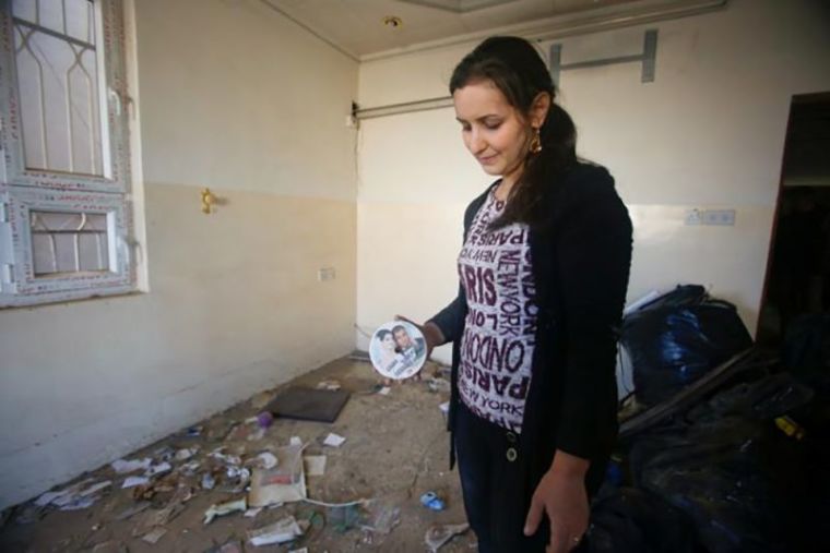 A Christian woman inspects a home in the town of Bartella east of Mosul, Iraq, after it was liberated from Islamic State militants, November 23, 2016.