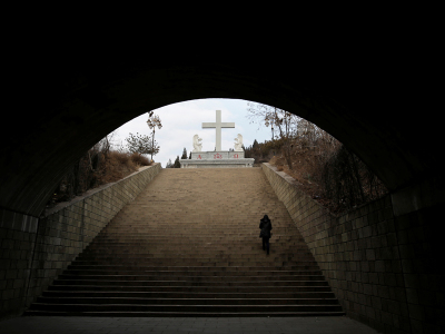A villager climbs up the steps toward a cross near a Catholic church on the outskirts of Taiyuan, North China's Shanxi province, December 24, 2016. Picture taken on December 24, 2016.