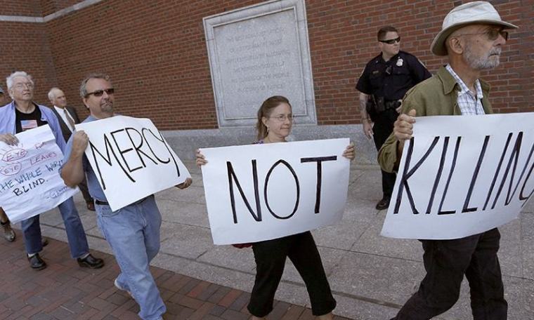Protesters against the death penalty walk with signs before the formal sentencing of convicted Boston Marathon bomber, Dzhokhar Tsarnaev in Boston, Massachusetts, June 24, 2015.
