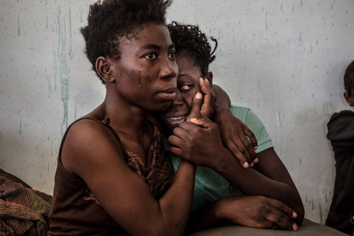 Two Nigerian refugees cry and embrace in a detention center for refugees in Surman, Libya, August 2016.