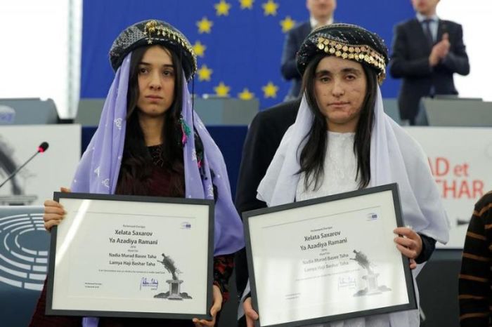 Nadia Murad (L) and Lamya Aji Bashar (R) pose with the Sakharov Prize on December 13, 2016, in Strasbourg, France.