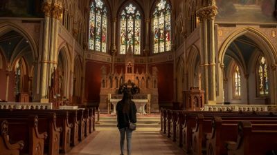 A woman stands inside a church.
