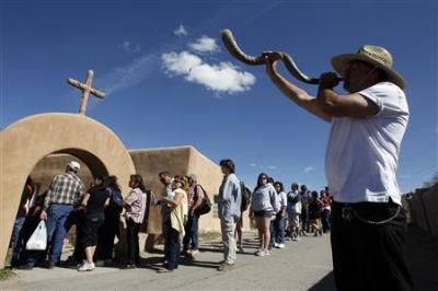 Arthur Medina blows a horn as people wait in line to enter El Santuario de Chimayo in Chimayo, New Mexico April 22, 2011.