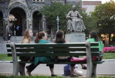 A statue of John Carroll, first Archbishop of Baltimore and founder of Georgetown University, overlooks a group of women seated on a bench on the Georgetown campus in Washington June 14, 2012.