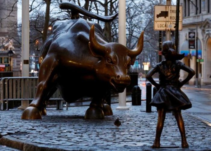 A statue of a girl facing the Wall St. Bull is seen, as part of a campaign by U.S. fund manager State Street to push companies to put women on their boards, in the financial district in New York, U.S., March 7, 2017.
