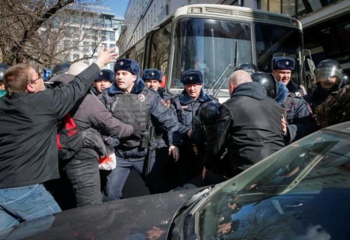 Law enforcement officers scuffles with opposition supporters blocking a van transporting detained anti-corruption campaigner and opposition figure Alexei Navalny during a rally in Moscow, Russia, March 26, 2017.