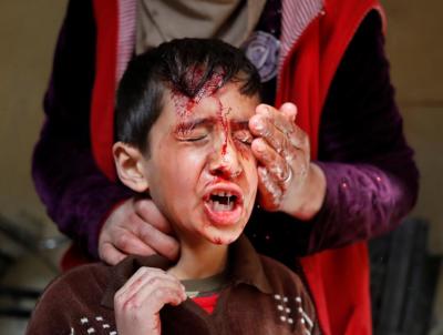 A mother of a boy injured during a battle between Iraqi troops and Islamic State fighters washes his face inside a house before they were rescued by Iraqi special forces in Mosul in this undated photo.