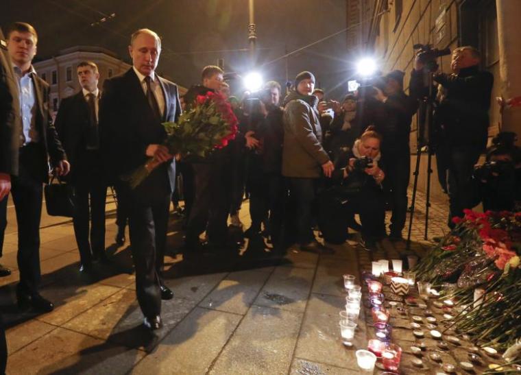 Russian president Vladimir Putin puts flowers down outside Tekhnologicheskiy Institut metro station in St. Petersburg, Russia, April 3, 2017.