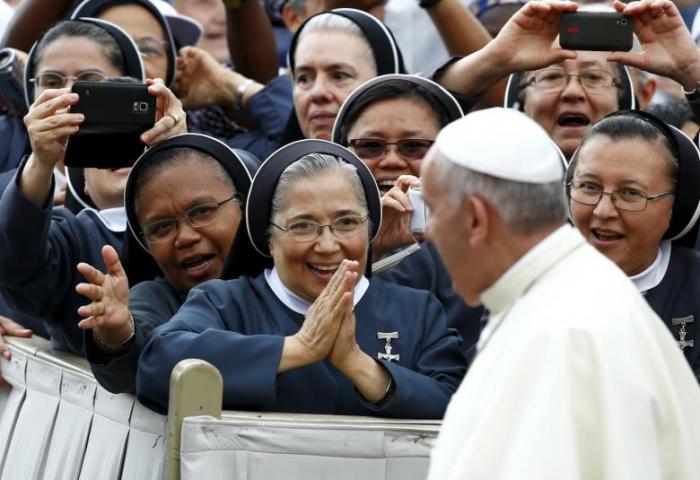 Nuns greet Pope Francis as he arrives to lead the weekly audience in Saint Peter's Square at the Vatican June 24, 2015.