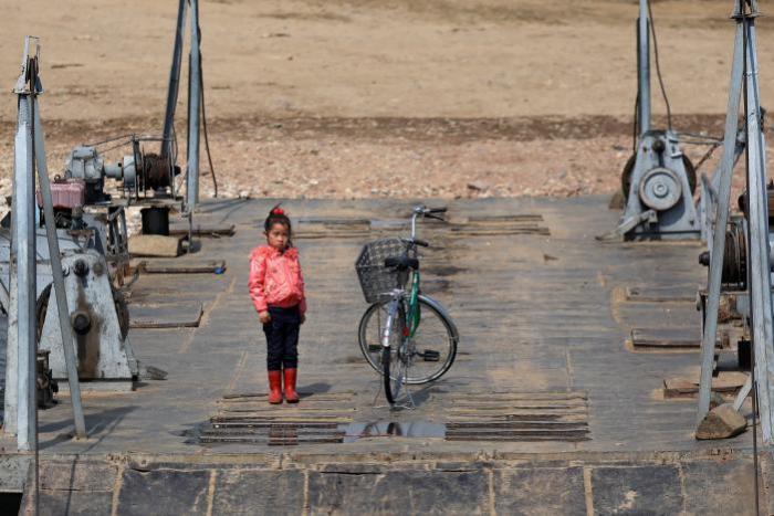 A girl stands on a ferry on the North Korean side of the Yalu River, just north of Sinuiju, North Korea, April 2, 2017.