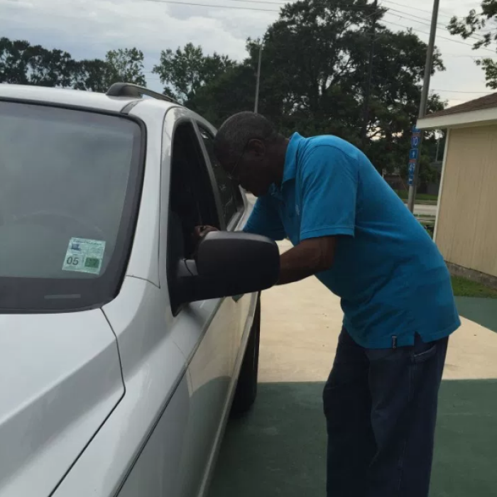 A member of Louisiana Avenue United Methodist Church of Lafayette, Louisiana prays for a commuter as part of the 2016 Good Friday Drive-Thru prayer event.
