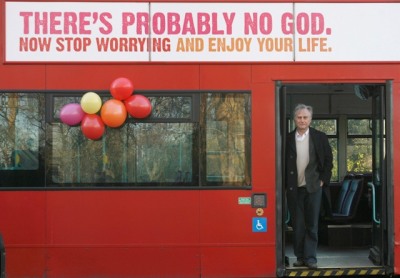 British scientist Richard Dawkins stands by the doorway of a bus in Italy with a banner that promotes an atheist message.