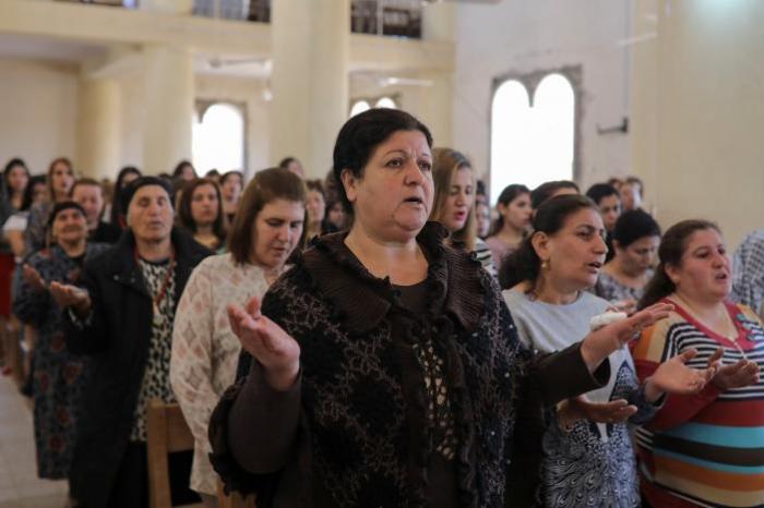 Believers take part in the Easter Mass in Mar Gewargis (St George) Chaldean Catholic church, which was damaged by Islamic State militants, in the town of Tel Esqof, Iraq, April 16, 2017.